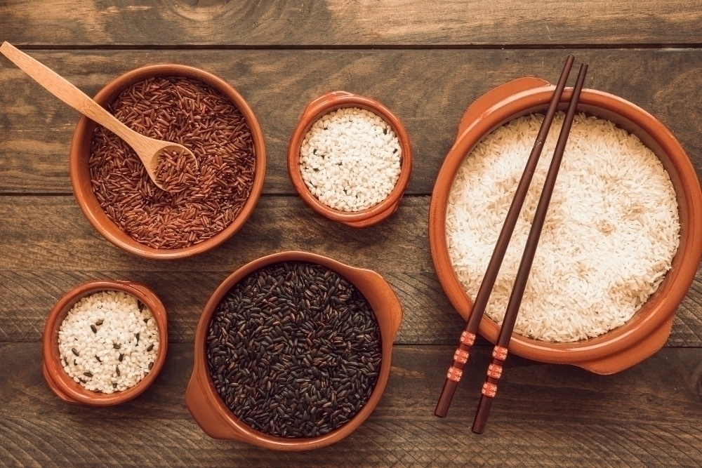 Bowl of red brown and white rice with wooden spoon and chopsticks