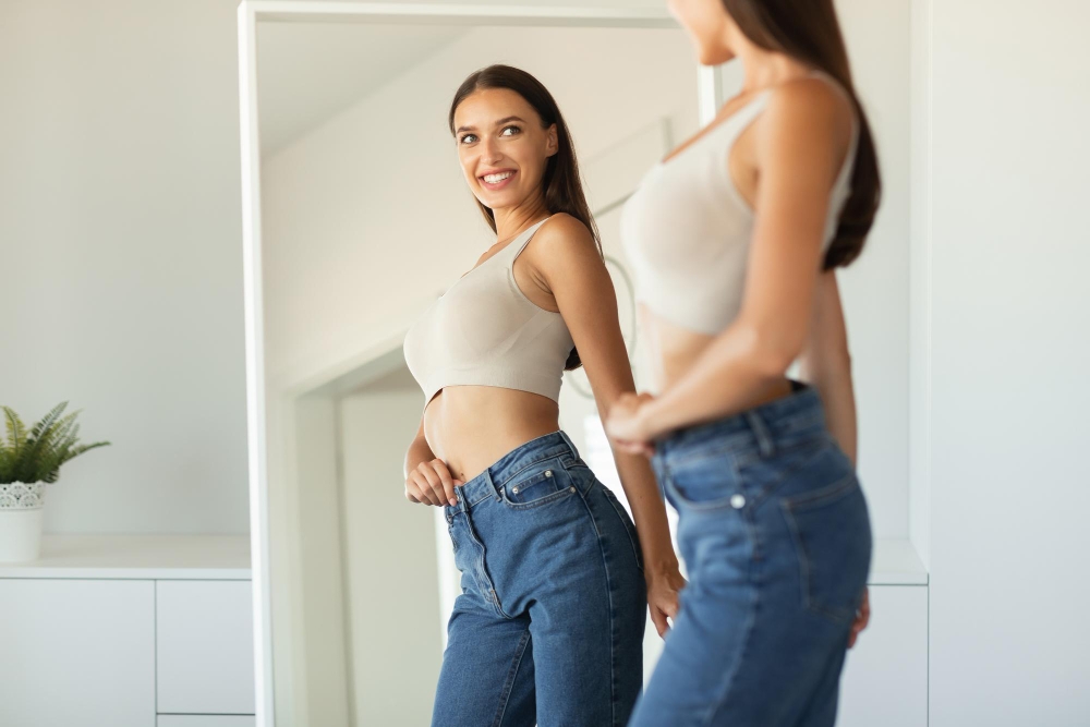 Cheerful Lady Posing Wearing Skinny Jeans Near Mirror Standing Indoors
