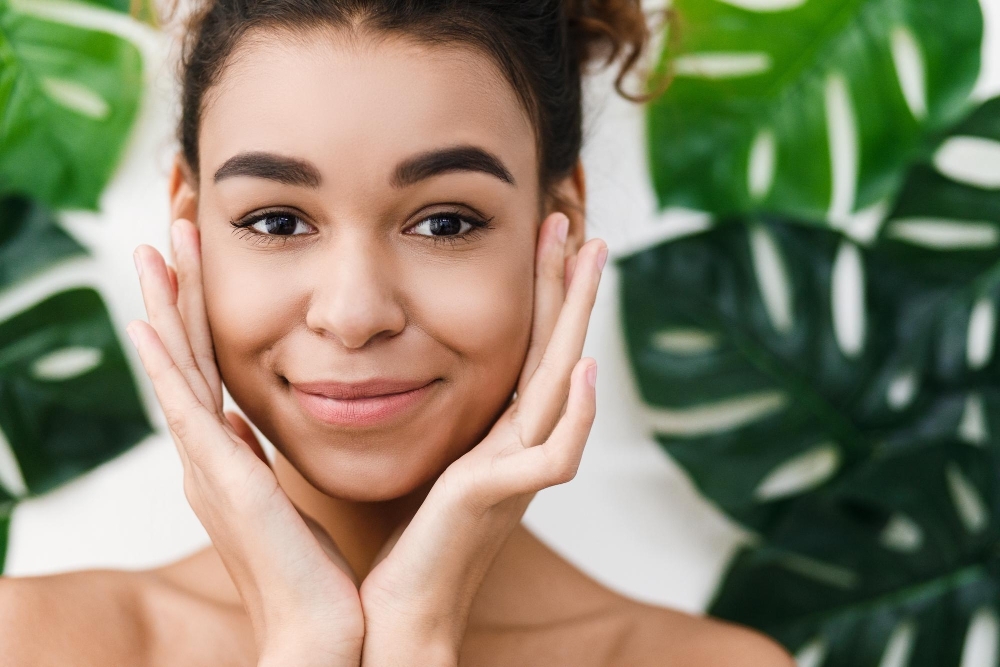 Natural beauty. African american woman over tropical leaves looking at camera