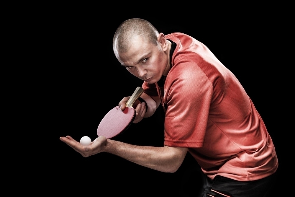Portrait of sports man male athlete playing table tennis isolated on black background