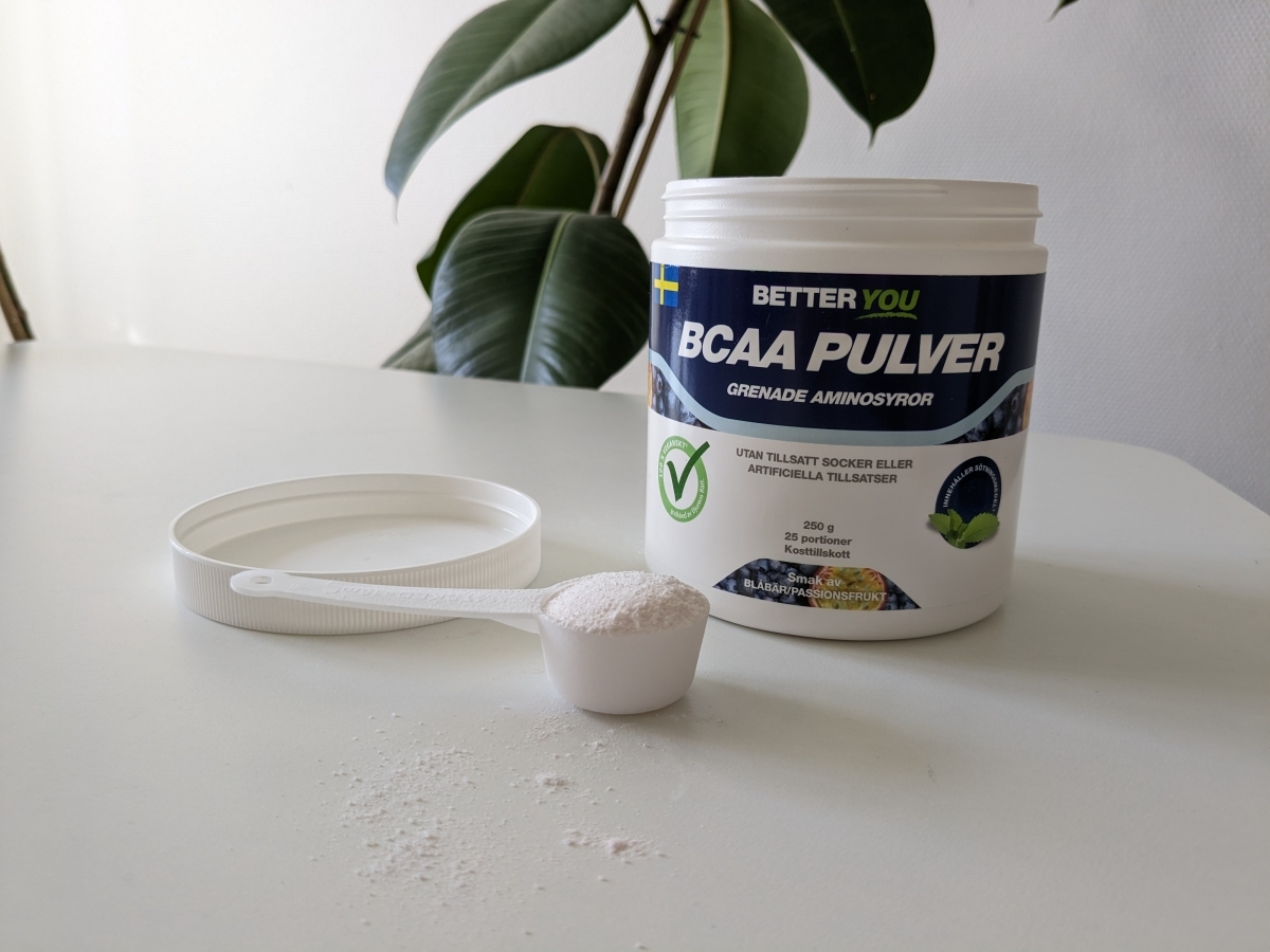 Better You BCAA Pulver med uppmätt skopa framför burken, foto från vårt test