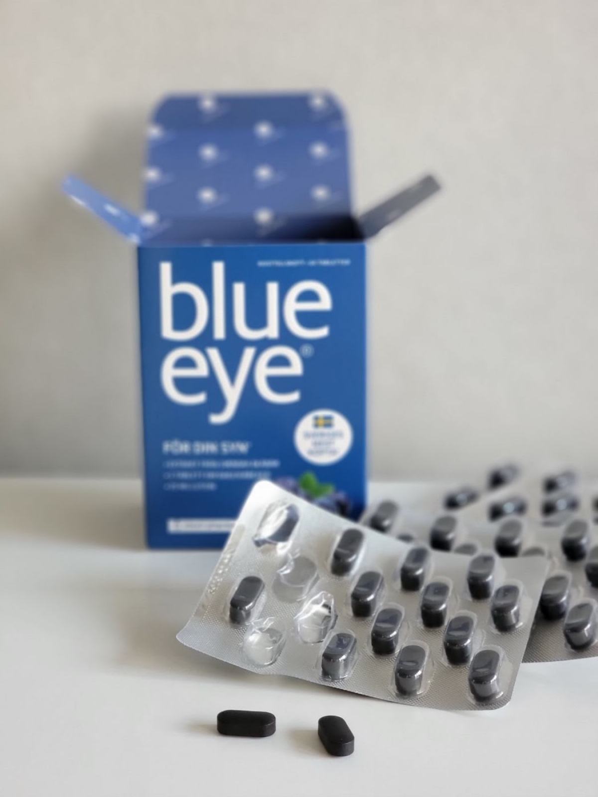 Blue Eye Blåbärsextrakt med öppnad ask och flera blister på bord, fotograferat av oss under testet