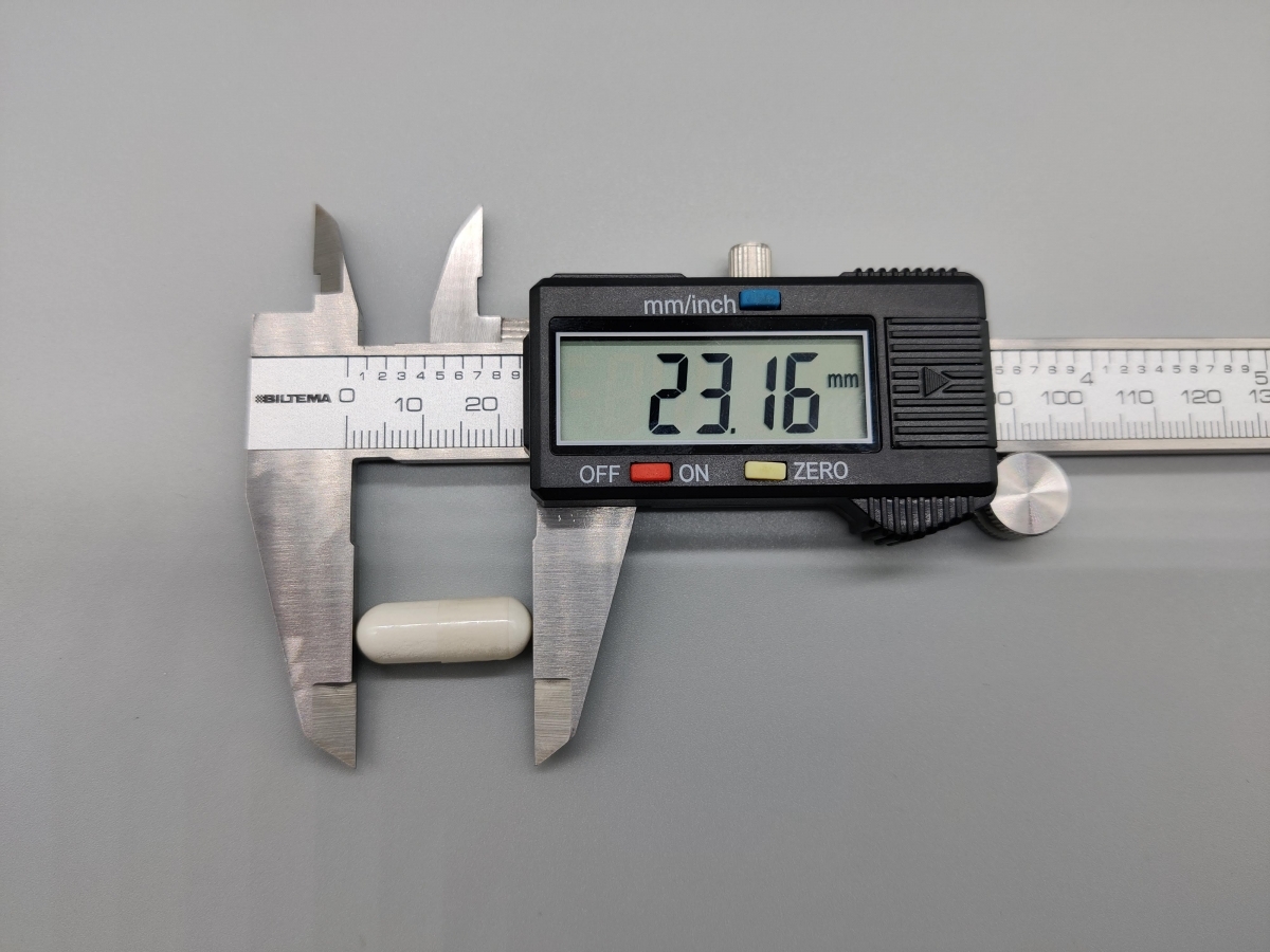 Skjutmått visar cirka 23 mm på en D3+K2-kapsel