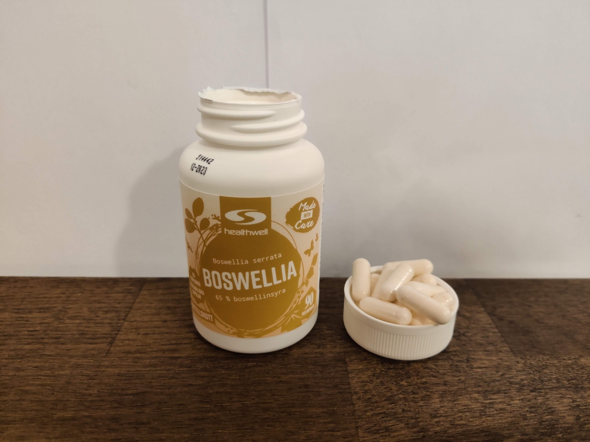 Healthwell Boswellia bredvid en liten samling kapslar, fotograferat av oss under testperioden