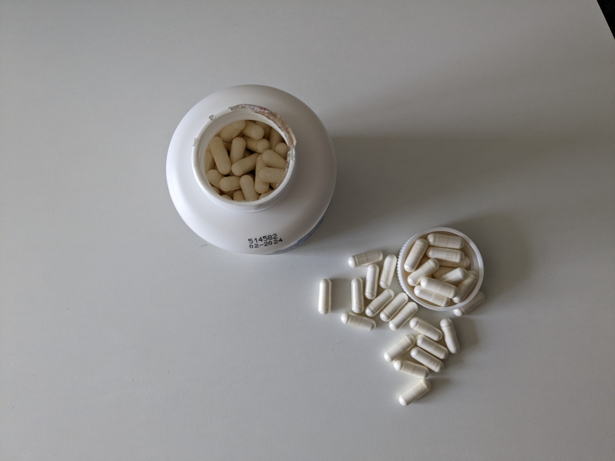 Öppen Core BCAA Caps sedd uppifrån med kapslar bredvid foto taget av oss under testet
