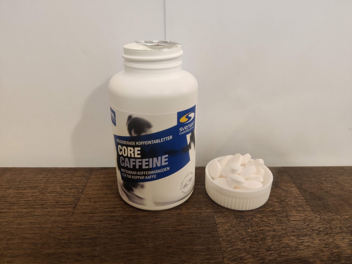 Core Caffeine öppnad burk med vita tabletter bredvid, fotad i vårt test