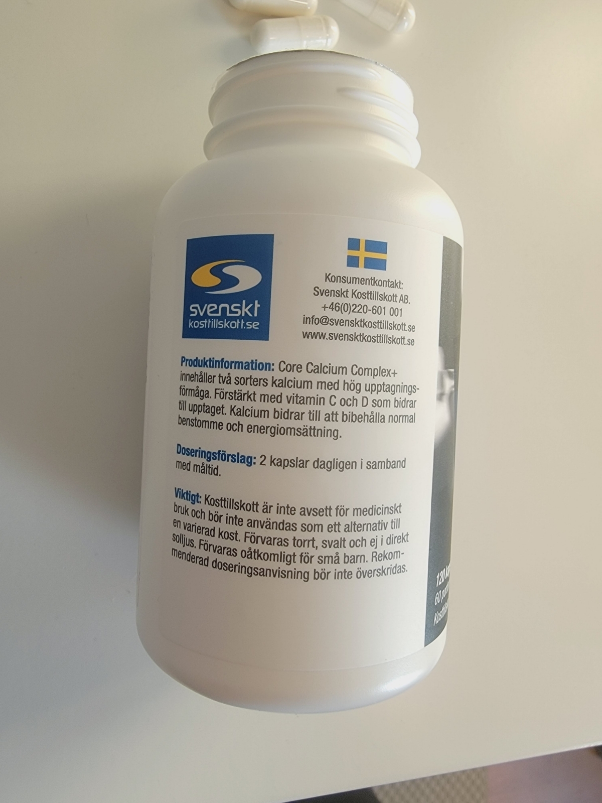 Närbild av baksidan med doseringsråd och svensk kontaktinfo på Core Calcium Complex+