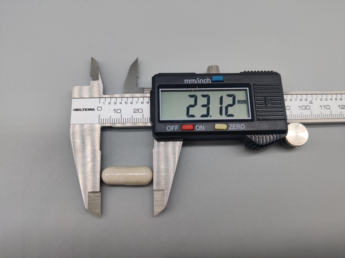 Skjutmått visar kapselns längd cirka 23 mm