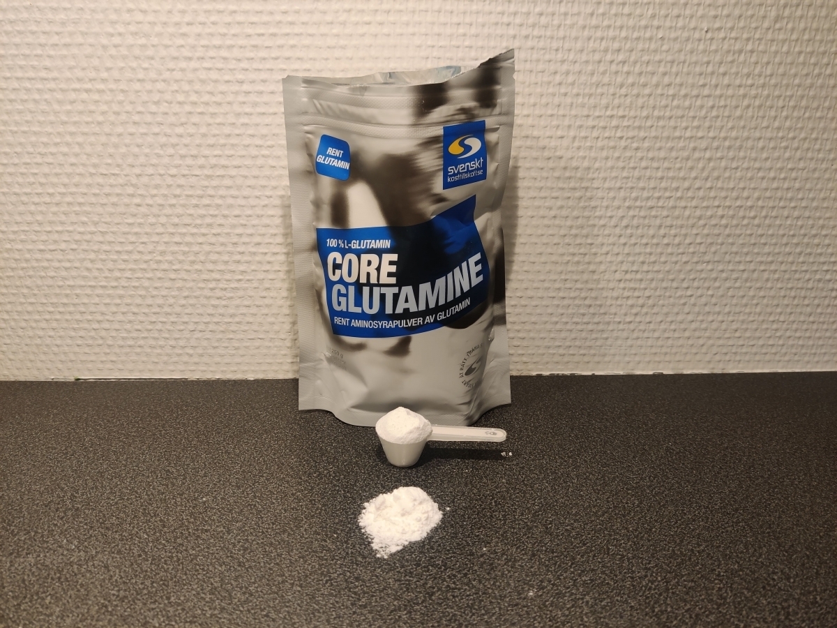 Core Glutamine med skopa och finkornigt pulver på köksbänken, taget av oss
