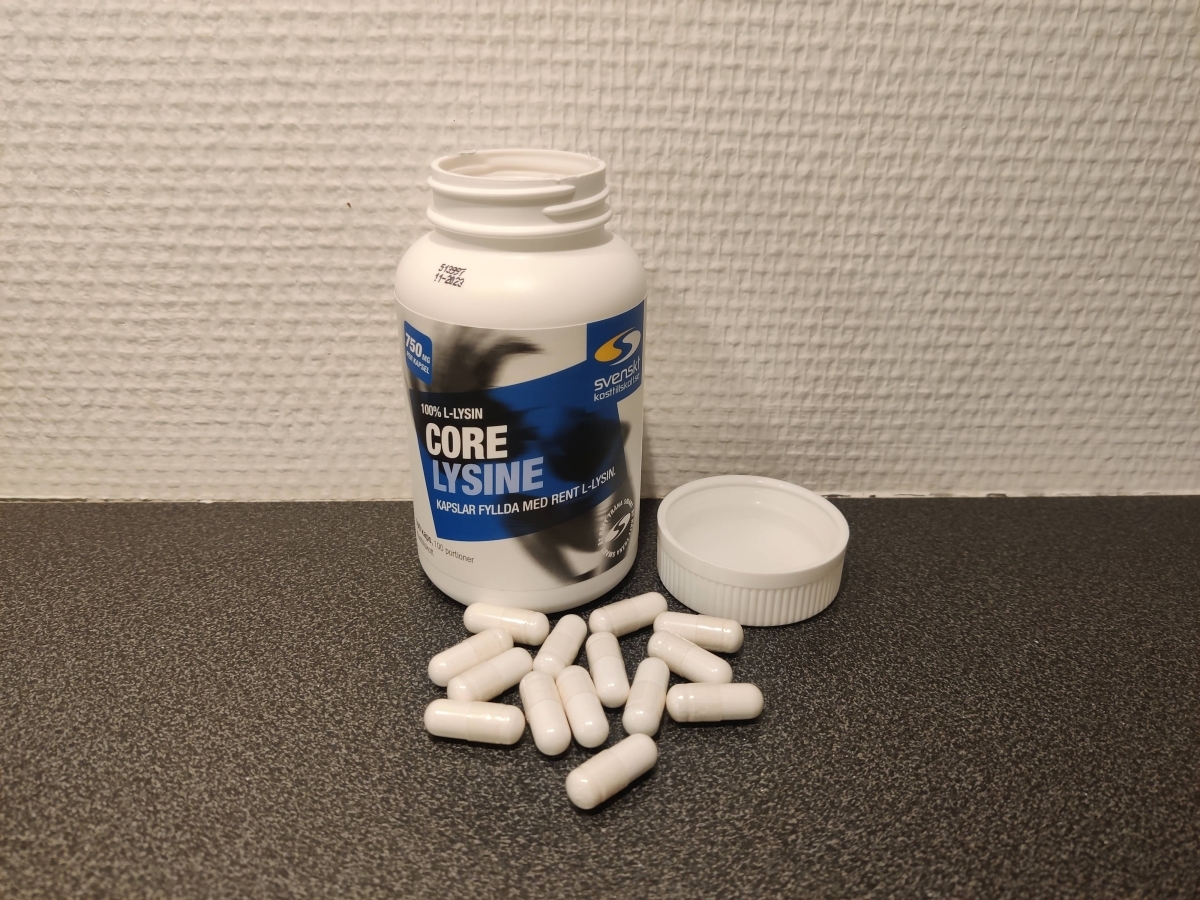 Öppen Core Lysine med kapslar på mörk bänkskiva, fotograferad av oss