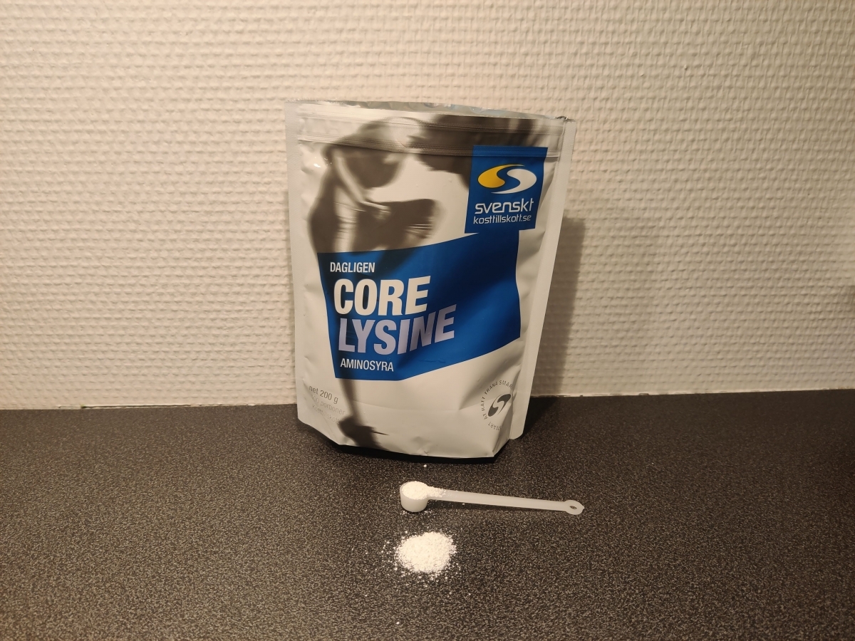 Skopa med vitt Core Lysine‑pulver framför förpackningen i köket, taget under vårt test
