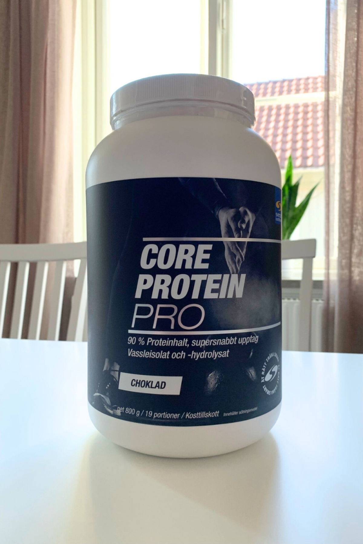 Core Protein Pro choklad på köksbord i dagsljus, foto taget av oss