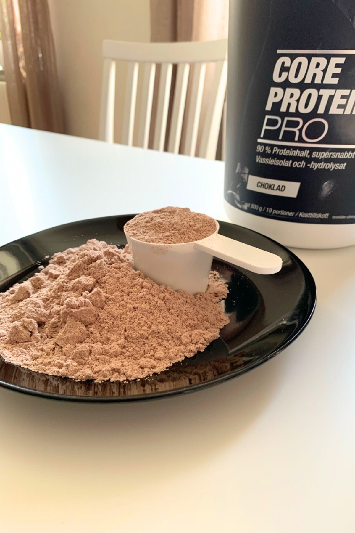 Core Protein Pro uppmätt pulver på svart fat med skopa
