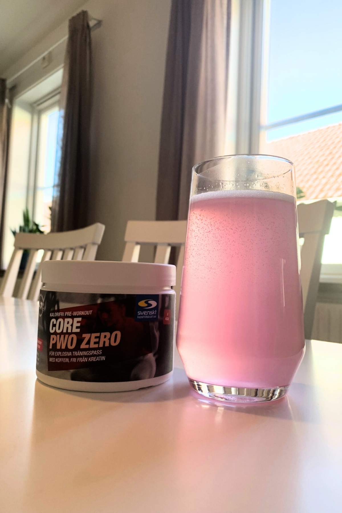 Blandad Core PWO Zero Pink Lemonade i glas bredvid burken, fotograferad av oss