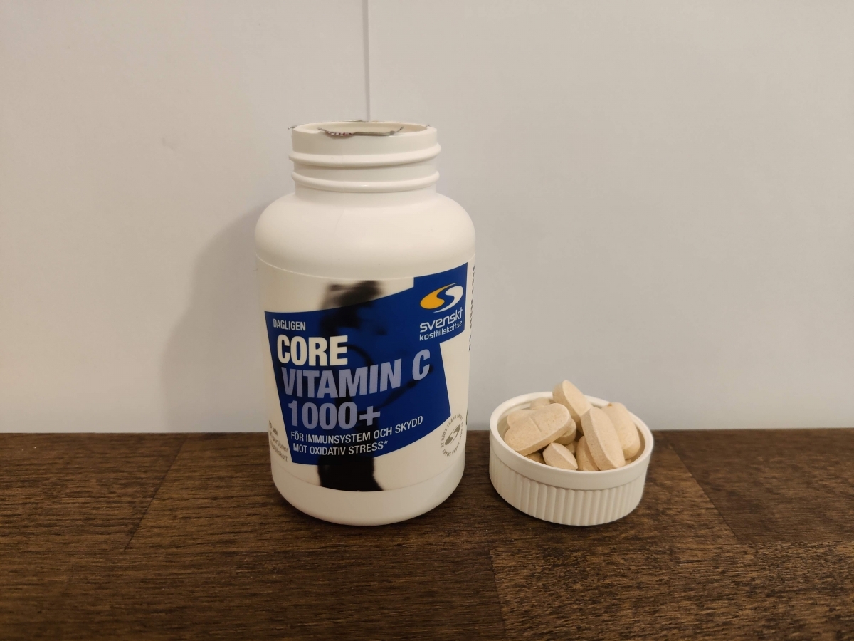 Core Vitamin C på träbord med tabletter bredvid, egen bild