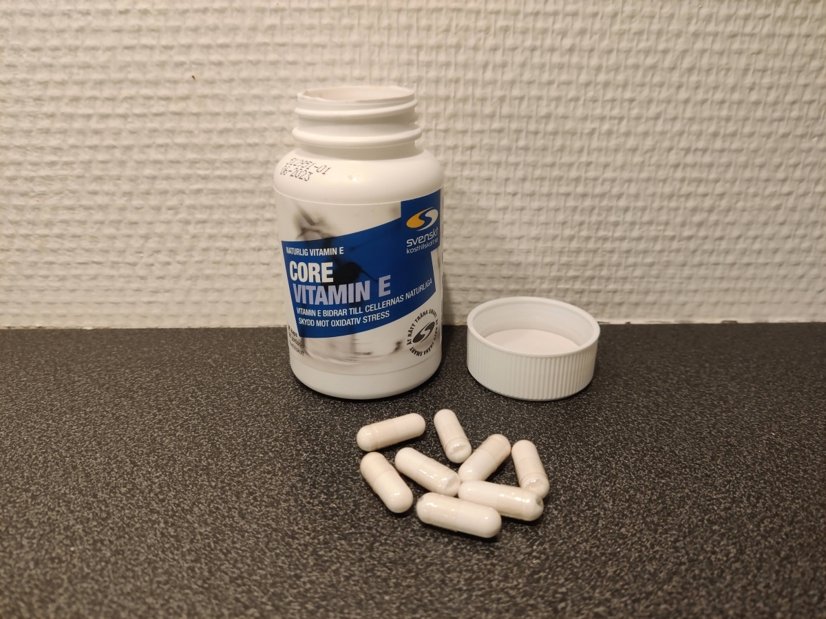 Core Vitamin E burk med öppet lock och kapslar på bänken, foto taget av oss under testet