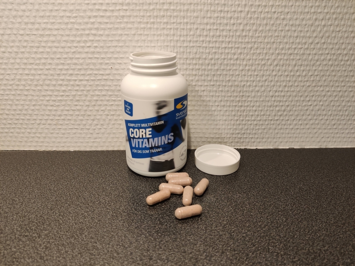 Core Vitamins öppnad med kapslar på bänk, fotad av oss i testet