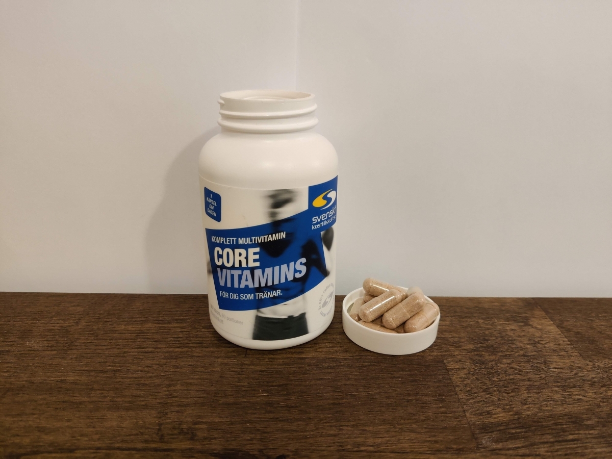 Core Vitamins på träbord med kapslar intill locket, vår testbild