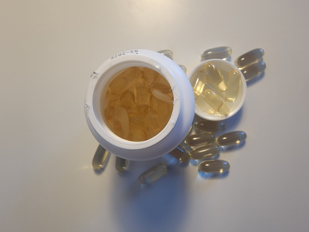 Vy ovanifrån ner i Diet CLA-burken med softgels och lock bredvid