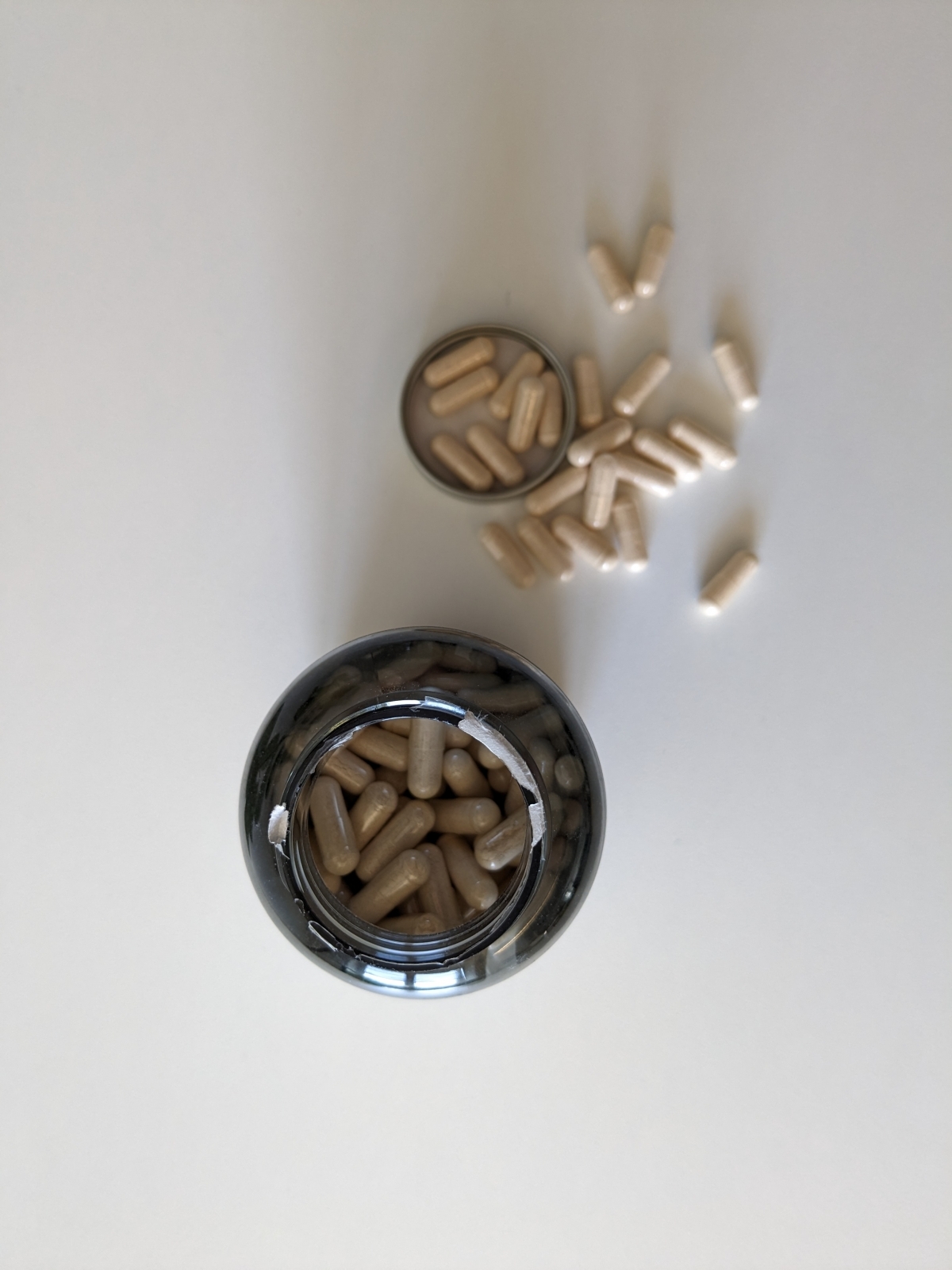 Öppnad burk sedd ovanifrån med kapslar utspridda, foto från vår femveckorsgenomgång