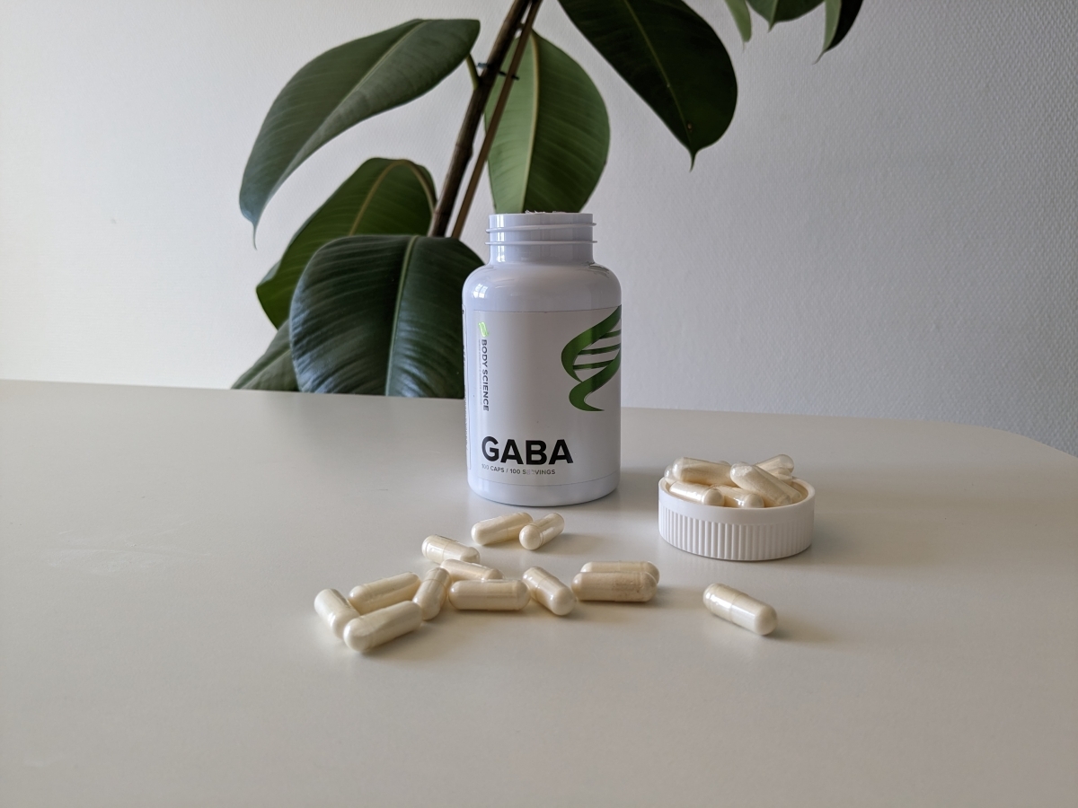 Vår egen bild av Body Science GABA 500 med öppnad burk och kapslar i dagsljus