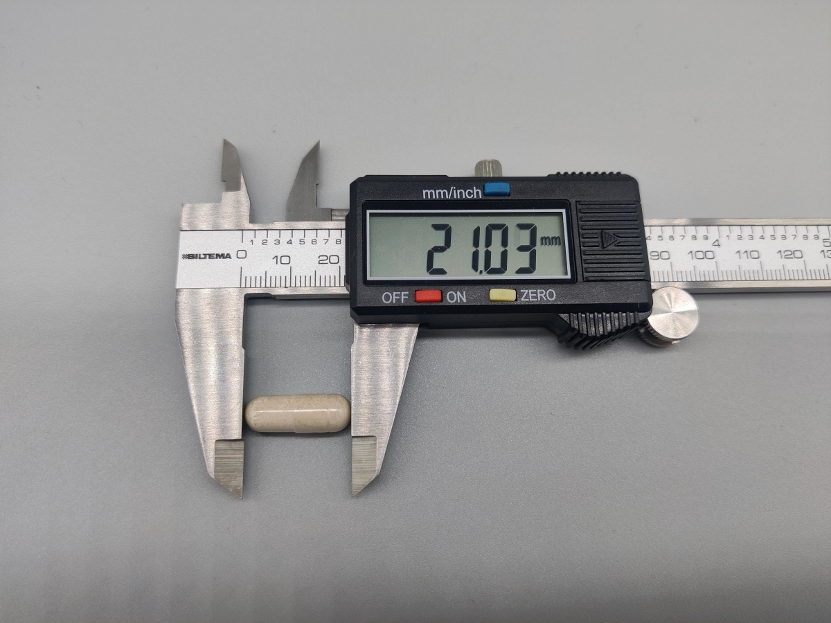 Närbild på kapsel uppmätt till cirka 21 mm med skjutmått