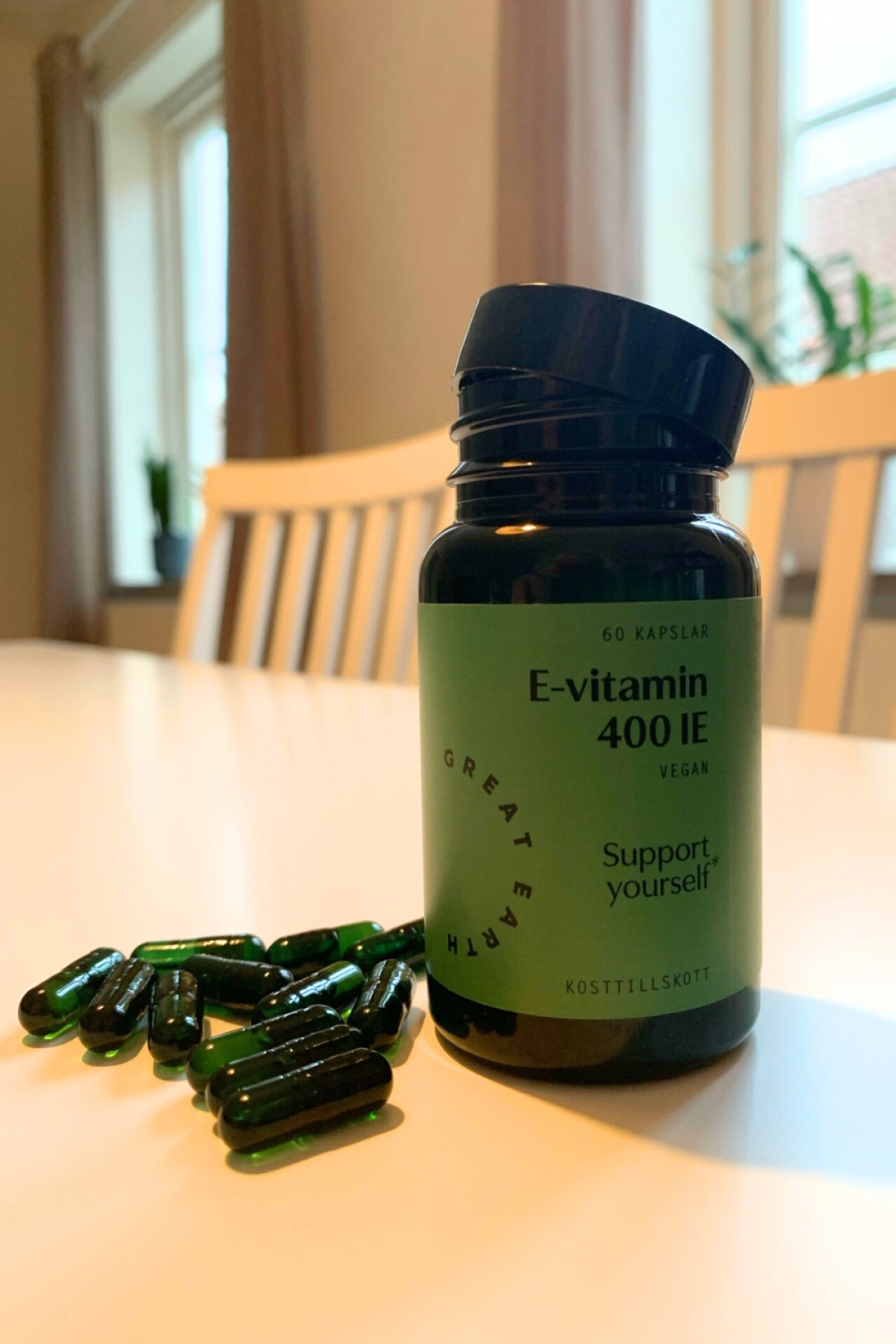 Great Earth E‑vitamin med kapslar utlagda på bordet