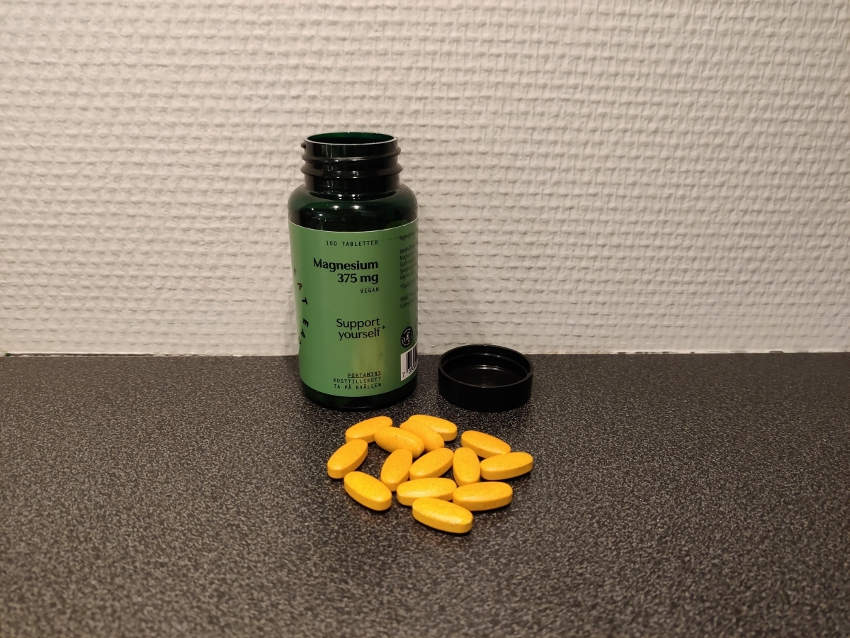 Great Earth Magnesium 375 mg öppnad burk med gula tabletter på bänken, taget av oss under testet