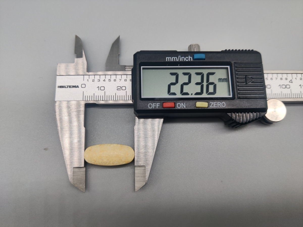 Närbild på tablett uppmätt till 22,36 mm med skjutmått, egen mätning under testet
