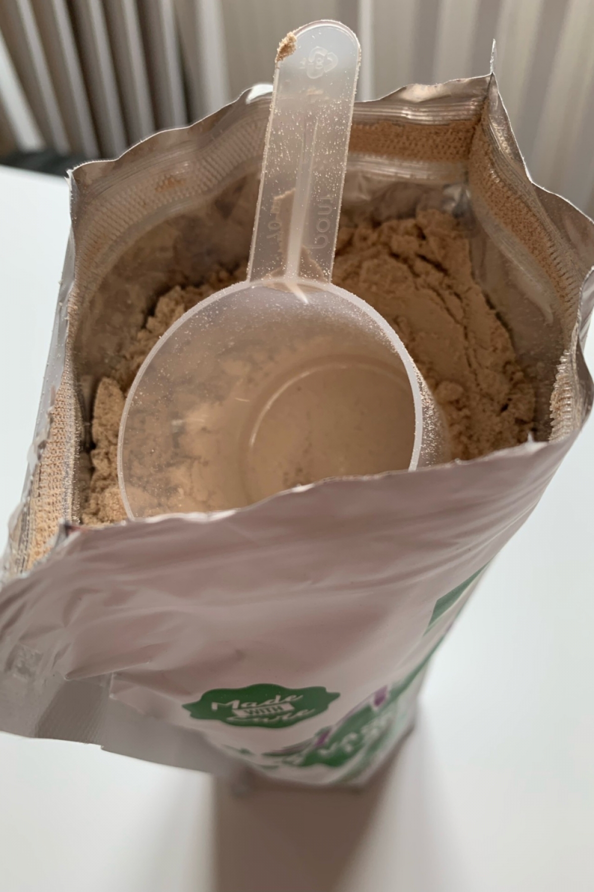 Öppen påse med skopa i chokladpulvret Healthwell Active Vassleprotein Laktosfri foto från vårt test