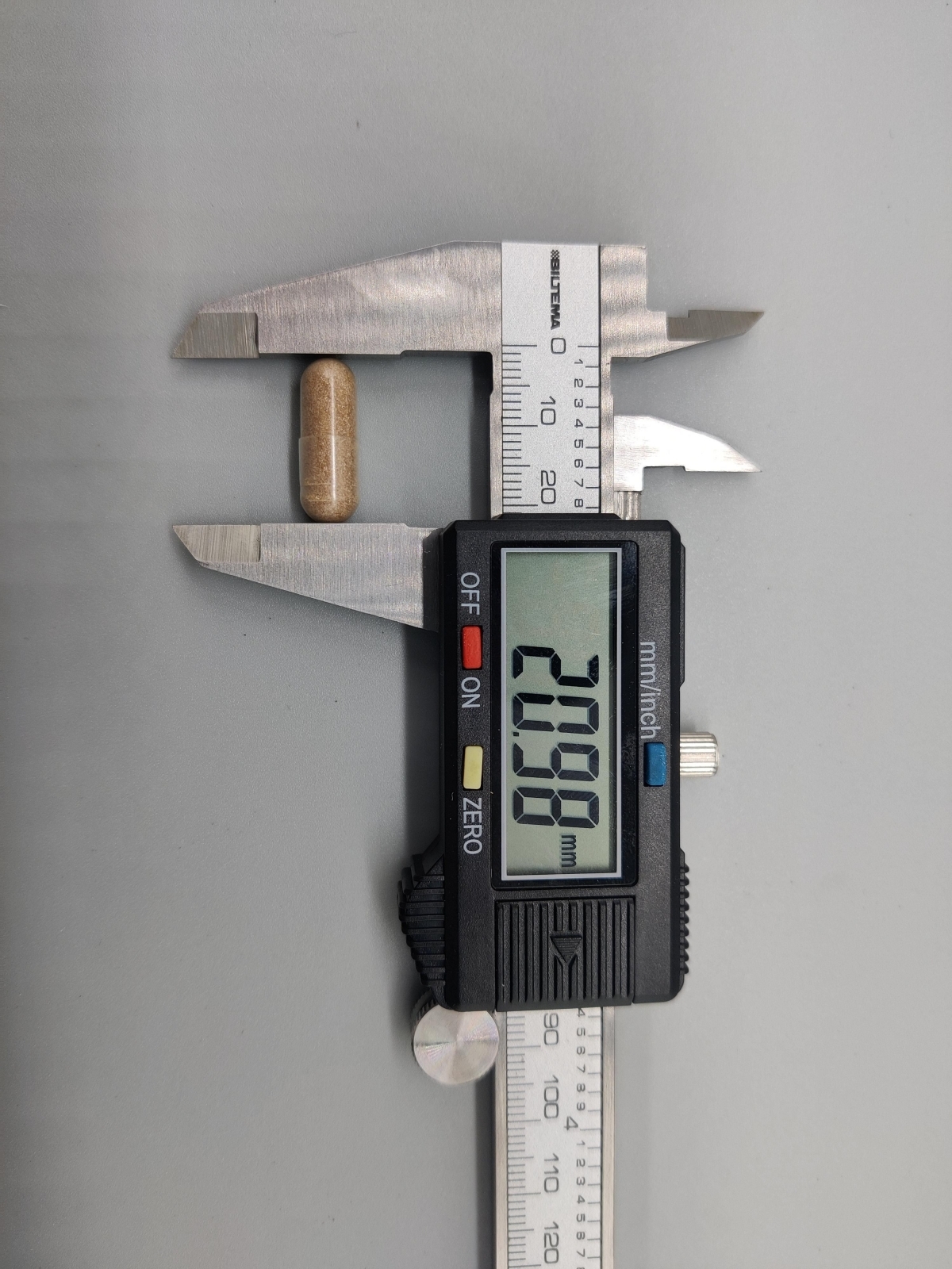 Kapsel från Healthwell Ashwagandha mätt till cirka 21 mm med skjutmått, tagen av oss under testet