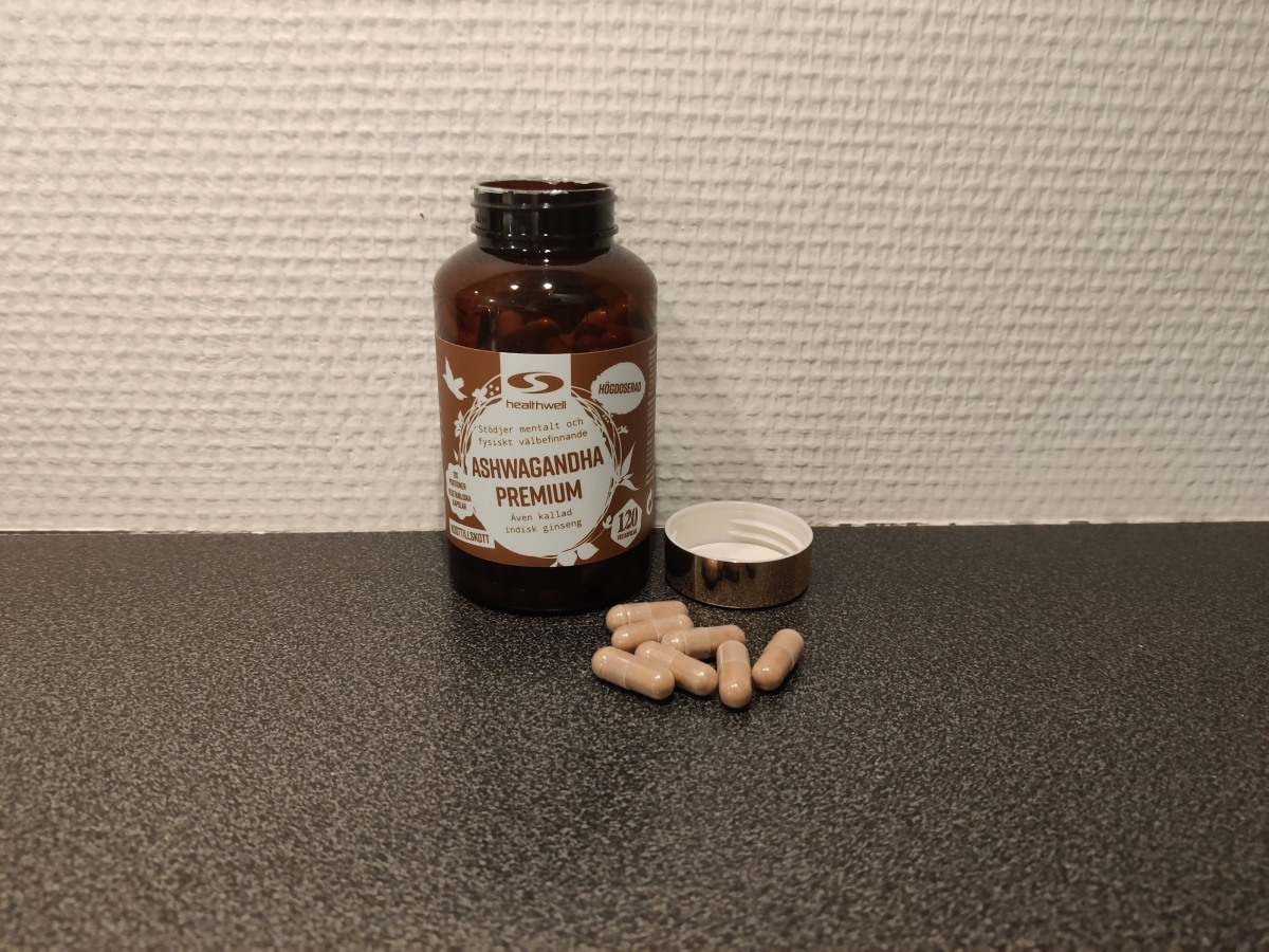 Healthwell Ashwagandha Premium öppnad burk med kapslar på bänken, tagen av oss under testet