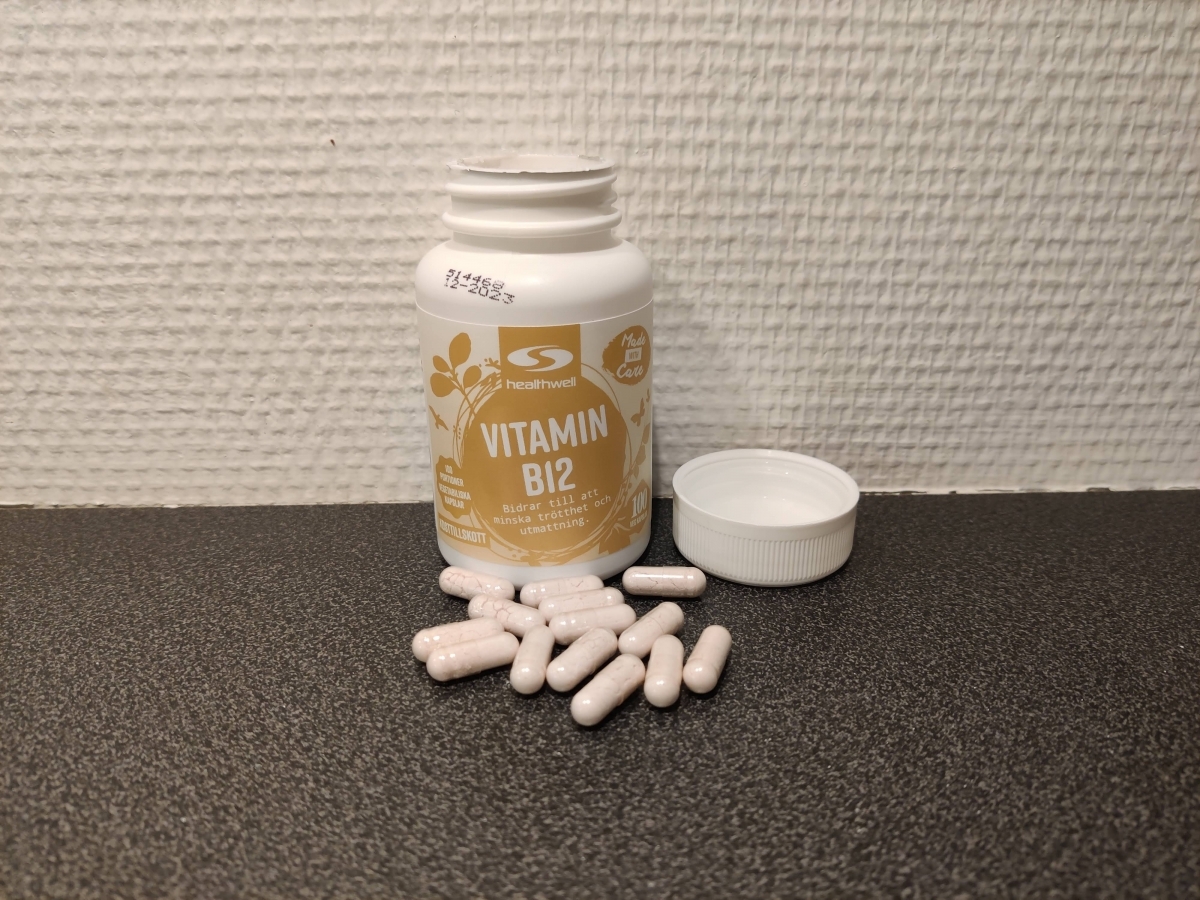 Healthwell Vitamin B12 500 Metylerad öppnad burk med kapslar på bänkskiva, foto taget av oss under testet