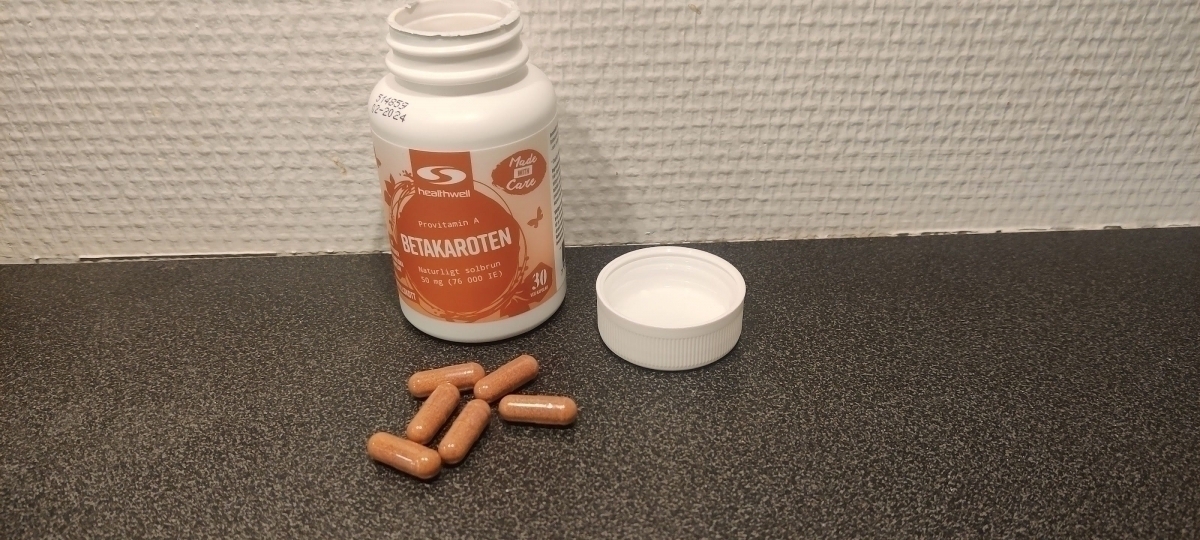 Healthwell Betakaroten 50 öppnad burk med kapslar på bänkskiva, foto taget av oss i testet