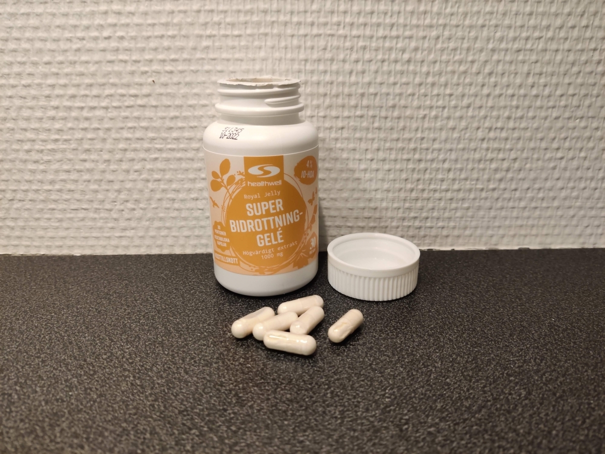 Healthwell Bidrottninggelé öppnad burk med kapslar på bänk, fotad av oss under testet