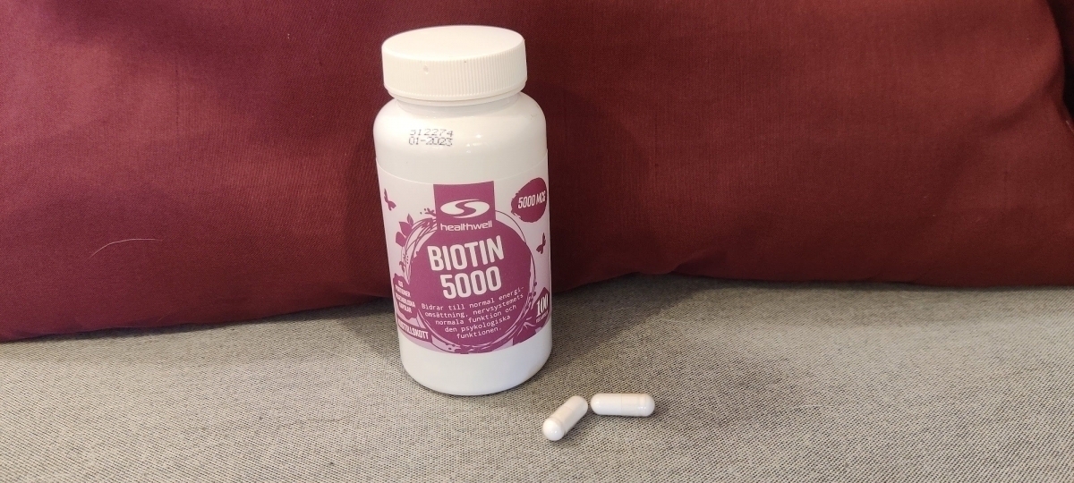 Healthwell Biotin 5000 och två kapslar på soffa foto taget av oss