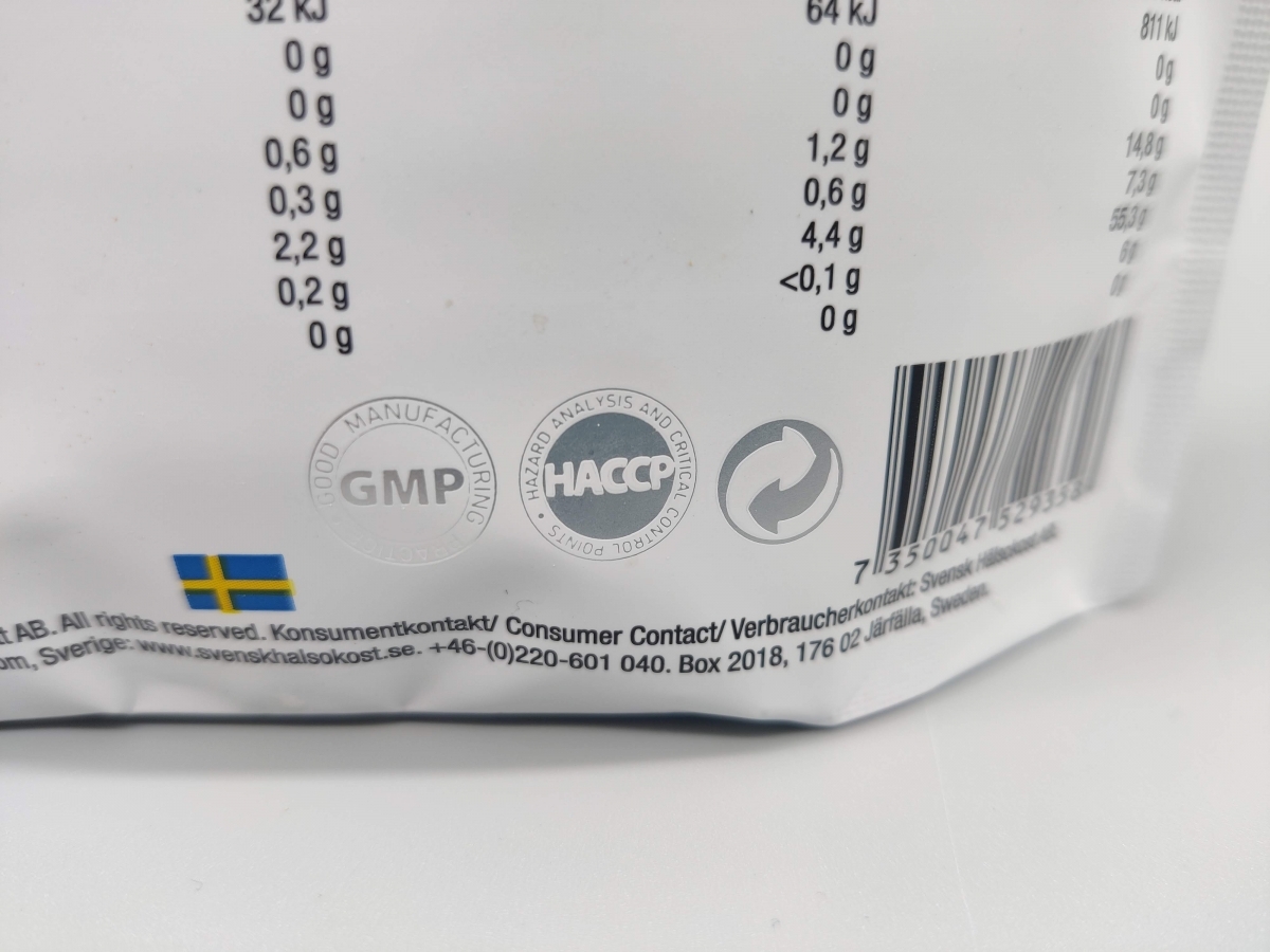 Närbild på kvalitetsmärkningar GMP och HACCP på Healthwell Detox Tea