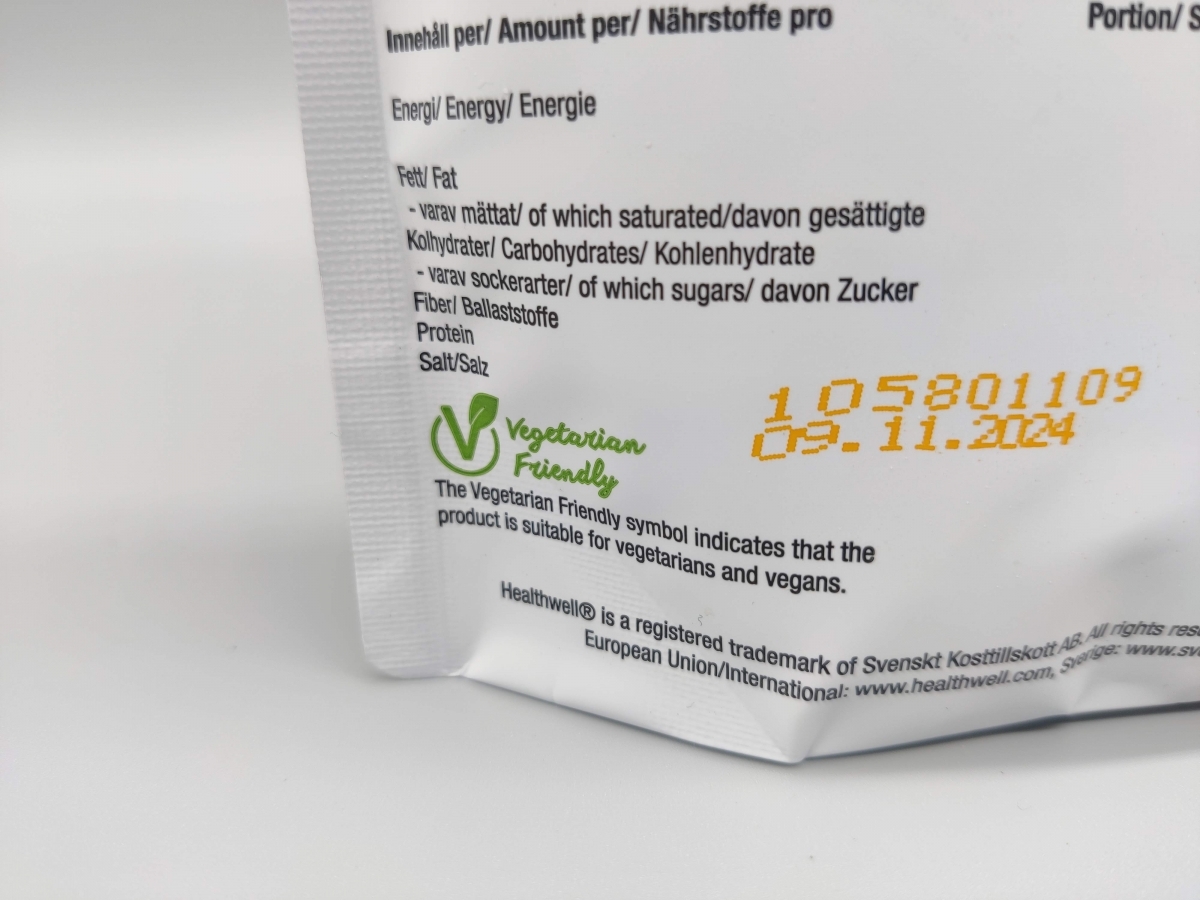 Närbild på vegetarisk märkning och bäst före-datum på Healthwell Detox Tea