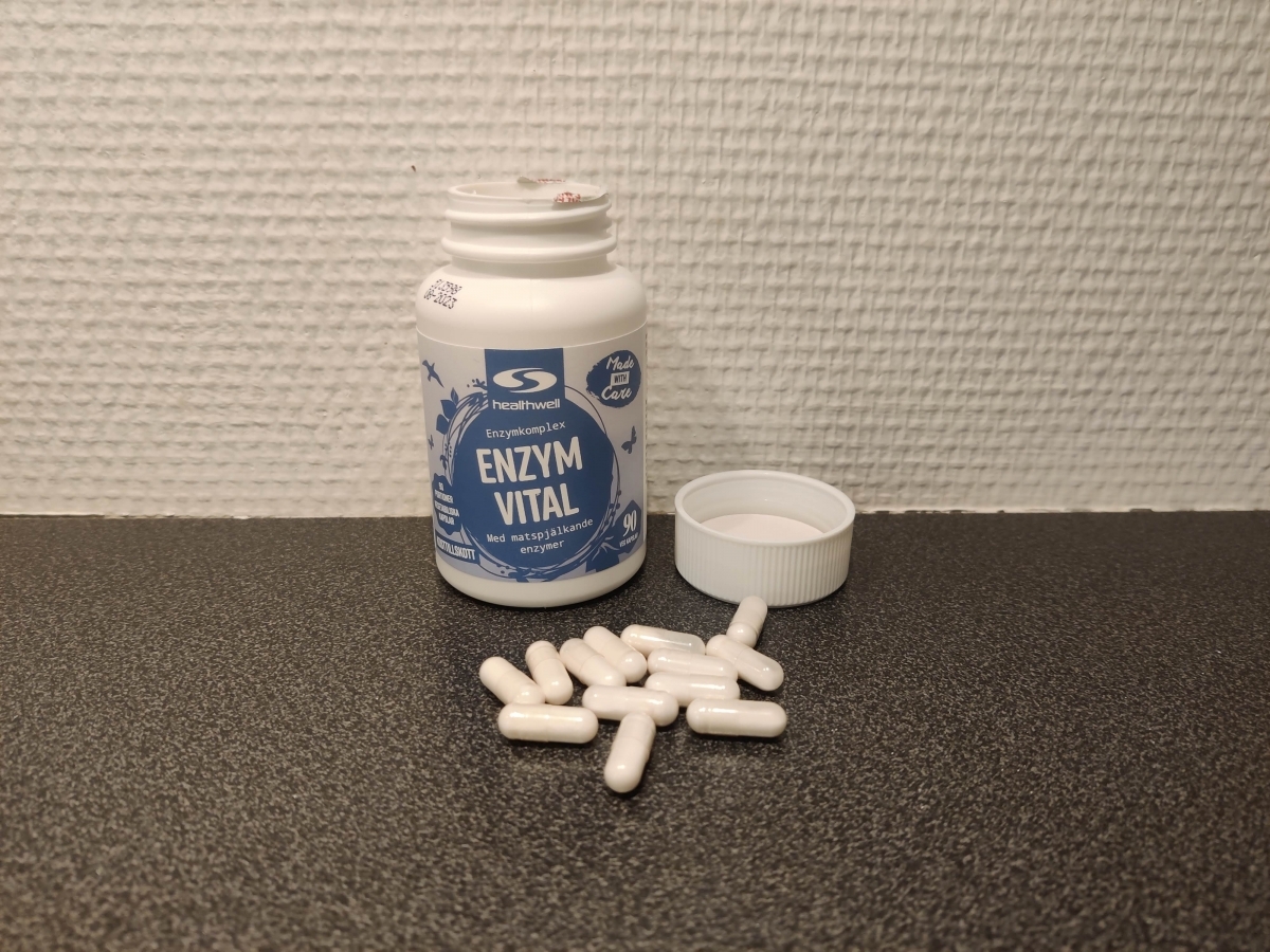 Healthwell Enzym Balans öppnad burk med kapslar på bänken, foto av oss
