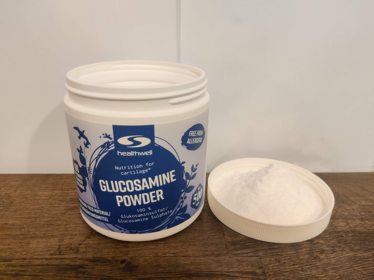 Närbild på finmalt glukosamin bredvid locket från vårt eget test