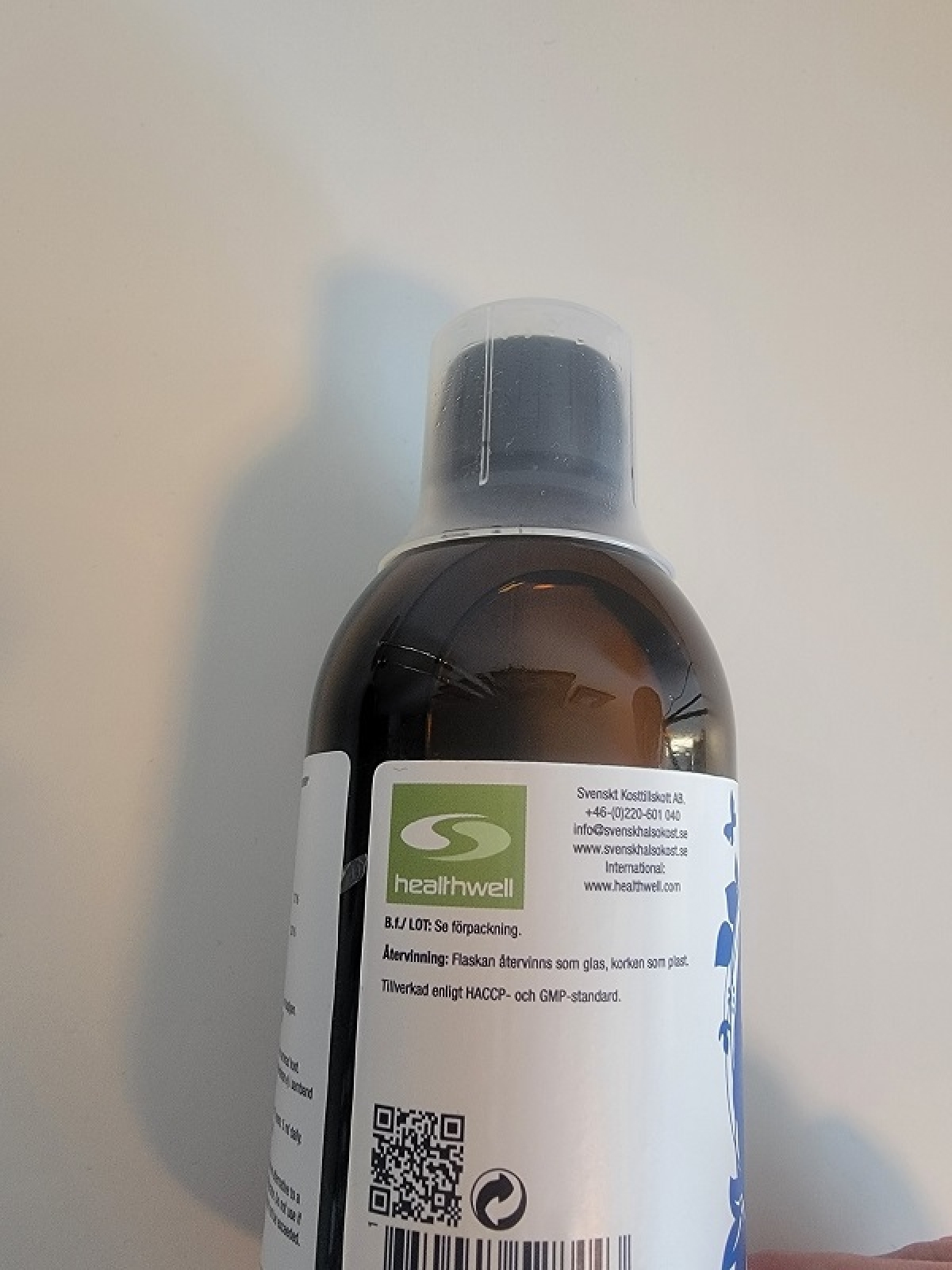 Sidovy av flaskan med QR-kod och återvinningsinformation fotograferad under testet