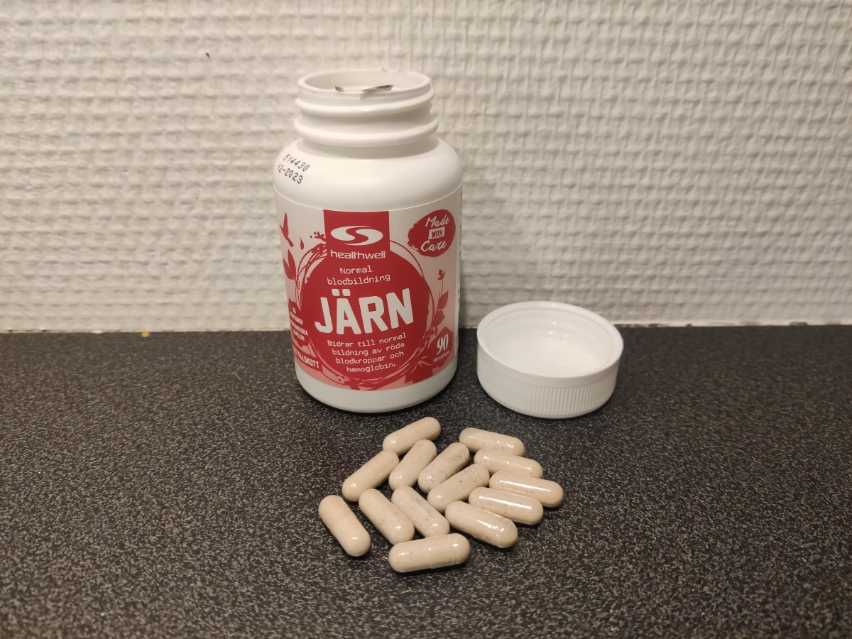 Healthwell Järn-kapslar på bänkskiva med öppnad burk, foto taget av oss under testet