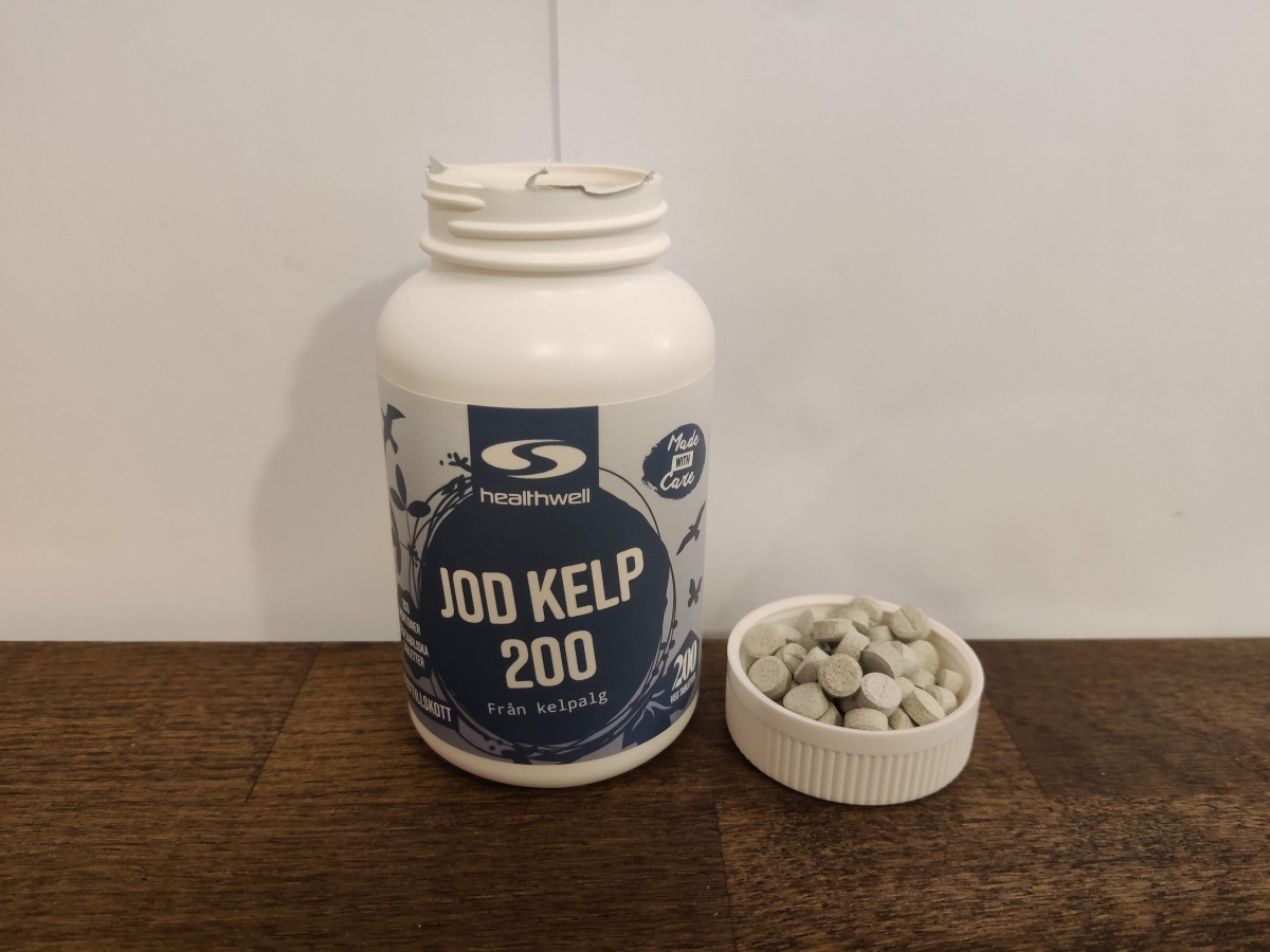 Healthwell Jod Kelp 200 på träbord med flera tabletter bredvid, eget foto