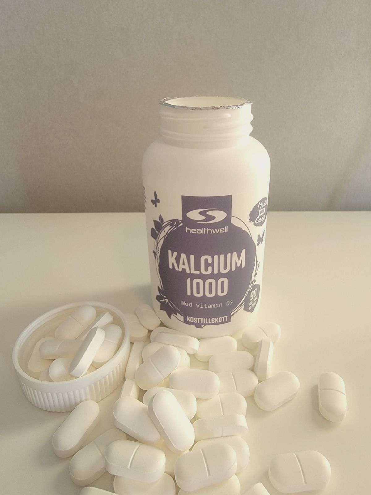 Healthwell Kalcium 1000 öppnad burk med tabletter på bordet, foto taget av oss under testet