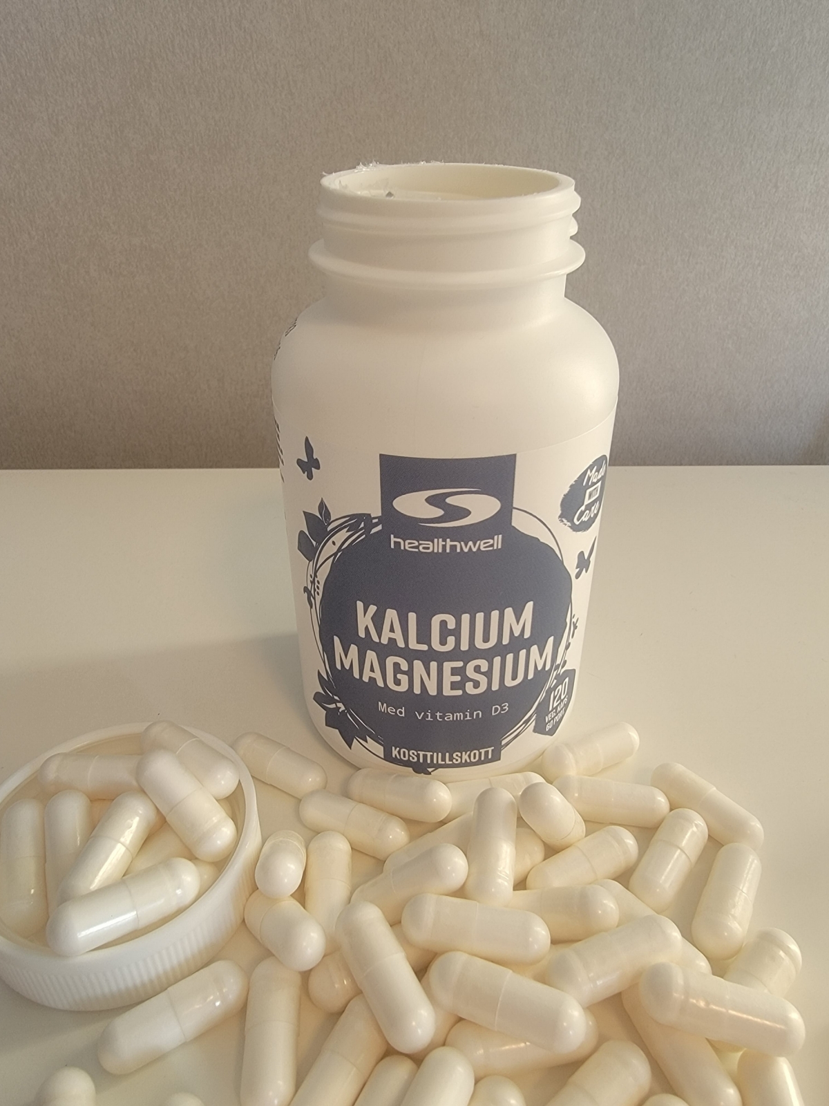 Healthwell Kalcium Magnesium, öppnad burk med kapslar på bordet, foto taget av oss under testet