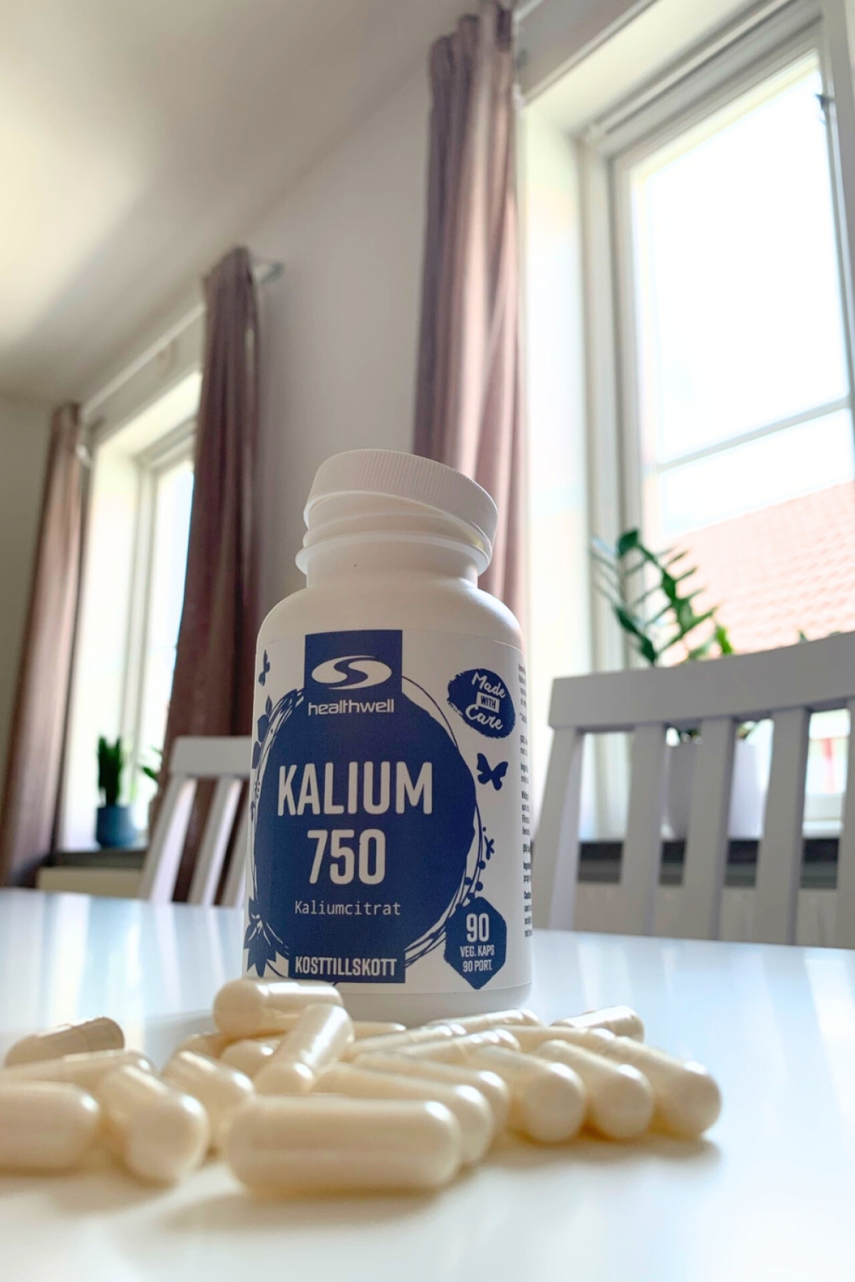 Öppnad burk Healthwell Kalium 750 med kapslar i förgrunden, vår bild