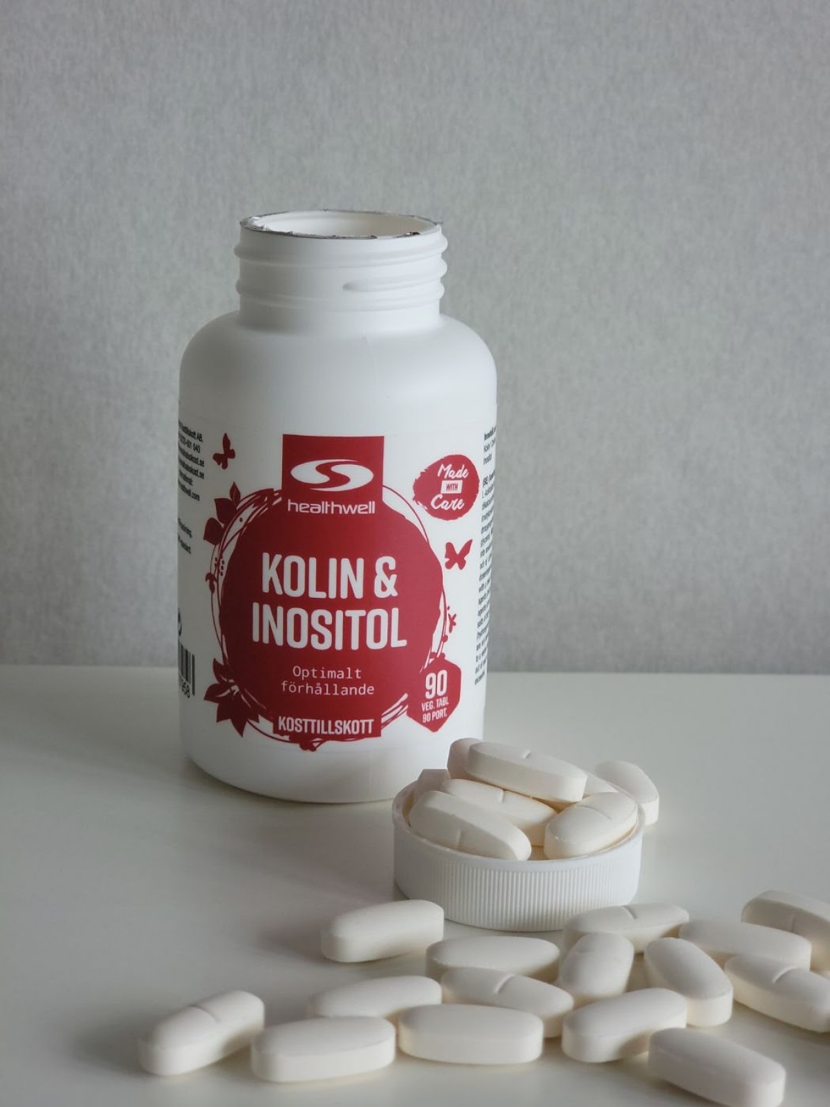 Healthwell Kolin & Inositol med utspridda tabletter på bord, taget av oss under testet