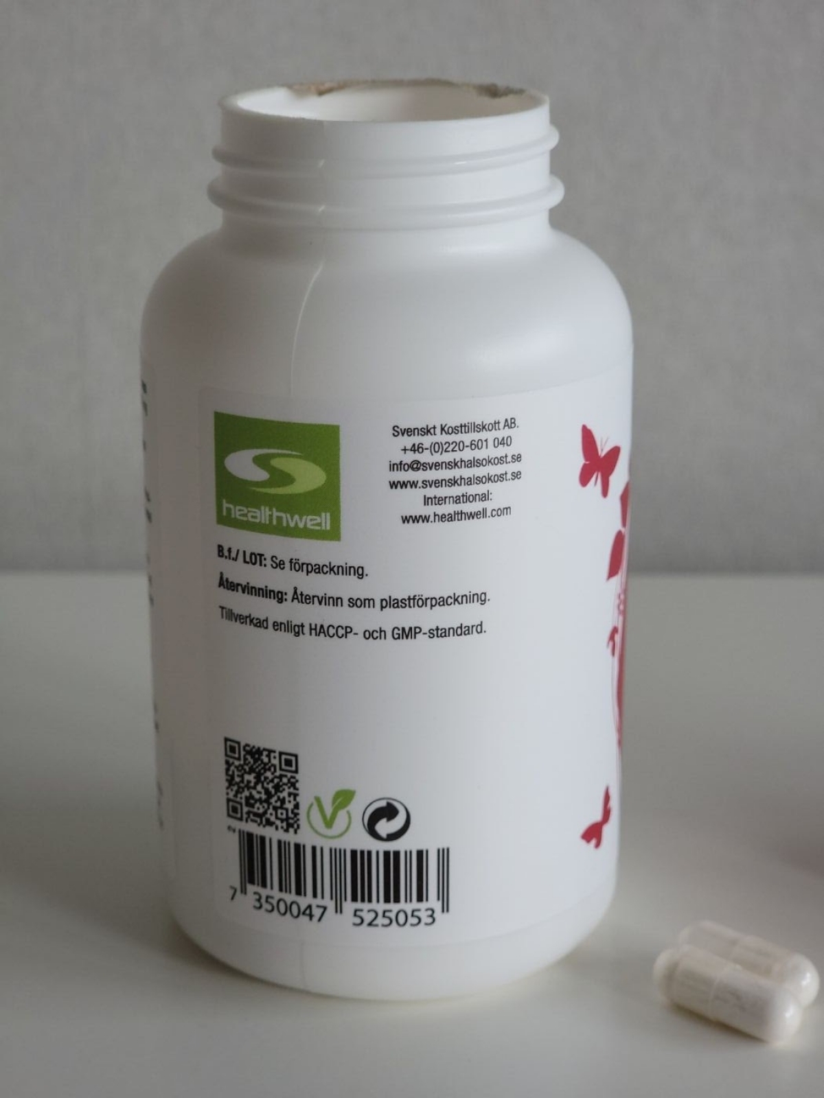 Etikett med kontaktuppgifter, QR-kod och vegansymbol på Healthwell-burken, fotograferad i vårt test