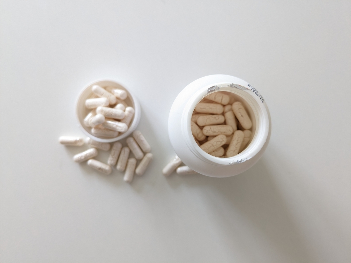 Öppen burk Healthwell Krom fotograferad uppifrån under testet med kapslar i burk och lock