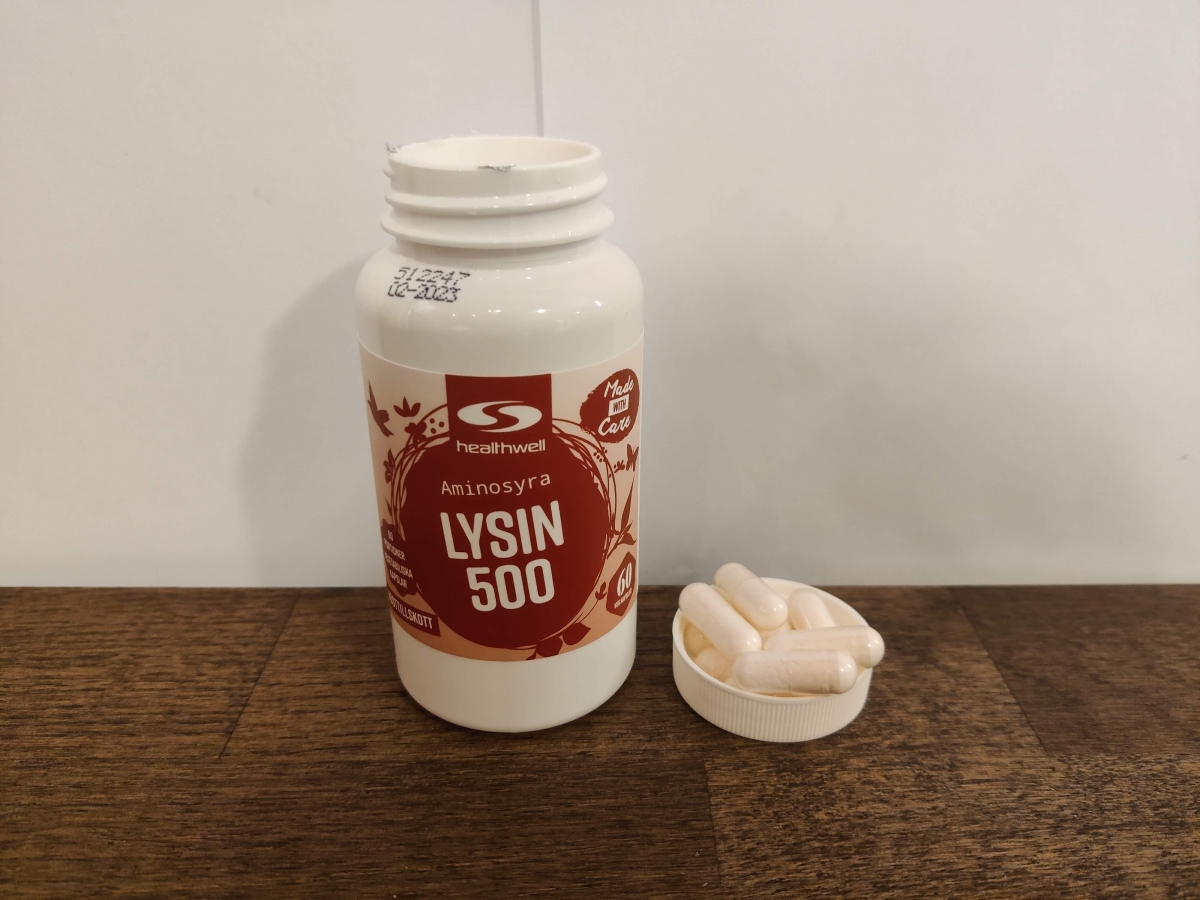 Närbild på Healthwell Lysin 500 med kapslar bredvid, fotograferad av oss
